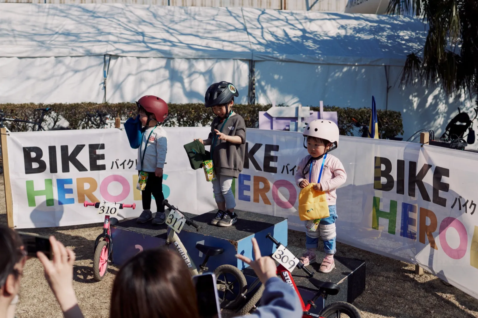 表彰台に立つキッズとBIKE HEROESのバナー